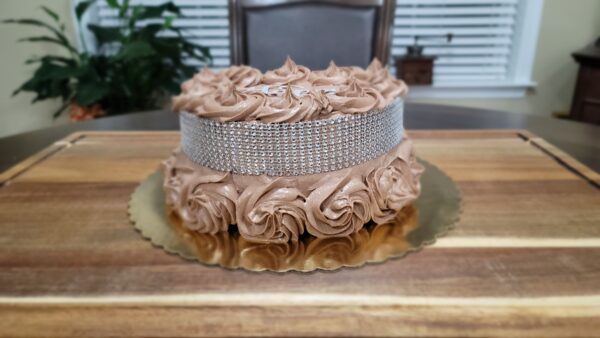 A cake with chocolate frosting and a diamond pattern on top.