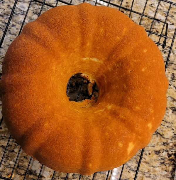 A bundt cake sitting on top of a rack.