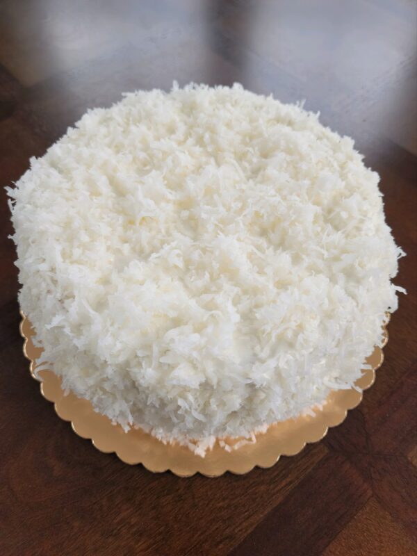 A white cake with coconut on top of it.