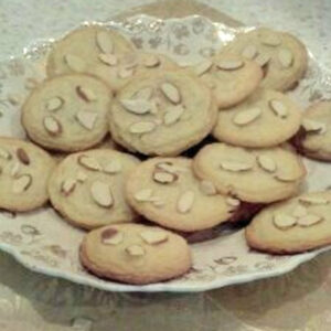 A plate of cookies with almonds on top.