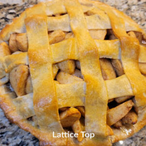 A pie with lattice top sitting on the counter.