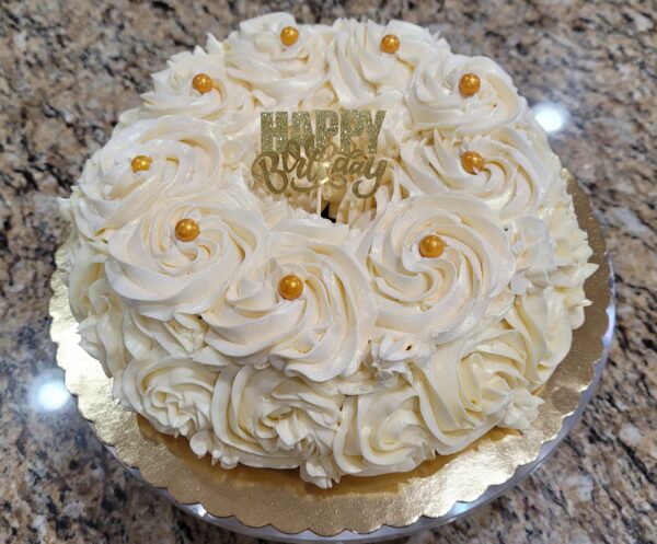 A white cake with gold candles on top of it.