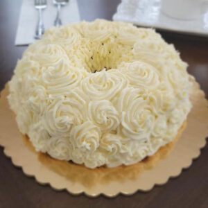 A cake with white frosting on top of a table.