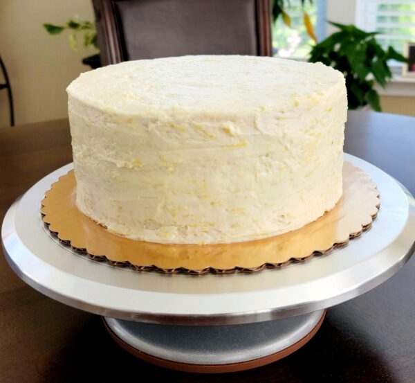 A white cake sitting on top of a wooden table.
