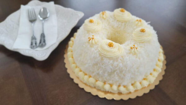 A white cake with frosting and orange decorations.